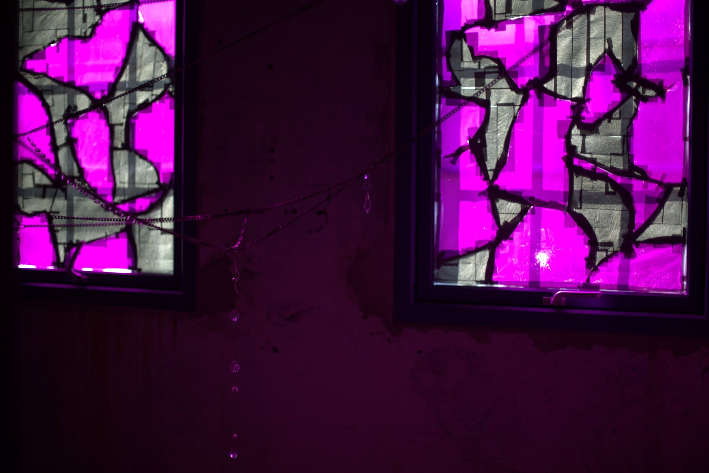 Close-up of the two magenta windows with a beaded chain hanging down between them, drops catching the light